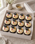 Graduation Cupcakes: twelve cupcakes in black cases with cream and gold swirls, topped in turn with small black sugar mortarboards with gold tassels, rolled sugar scrolls tied with red ribbon and discs reading GRAD