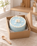 Small baby blue bento cake with piped clouds and white sugar paste bootees