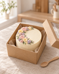 Small ivory bento cake with a crescent of piped buttercream flowers