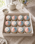 Gender Reveal Cupcakes: twelve cupcakes in white cases, each swirled half blush pink and half sky blue, six topped with a white sugar disc reading HE OR SHE?