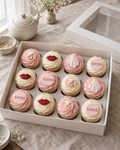 Hen Party Cupcakes: twelve cupcakes in white cases with blush pink and white swirls, topped in turn with flat sugar discs: a pink sugar diamond ring, a pair of red lips, a tiny white veil, and plaques reading BRIDE and SQUAD in pink letters
