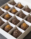 A box of Biscoff and Energy protein balls: chocolate balls topped with Biscoff crumb next to dark brown textured Energy balls