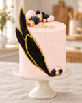 Feather Wing Bento Cake: pale pink buttercream, gold-edged black feathers, black, gold and pink spheres and a Love topper