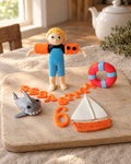 Swimming Personalised Cake Topper laid out on a wooden board