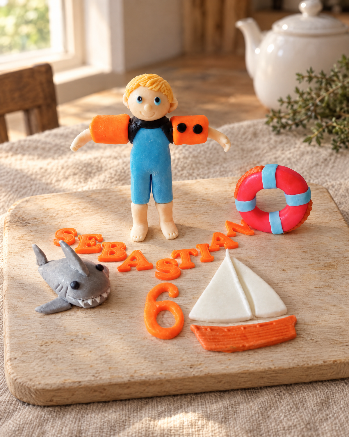 Swimming Personalised Cake Topper laid out on a wooden board