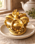Gold Chocolate Crown Cake Topper on a cream plate