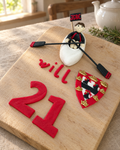 Kayak Personalised Cake Topper laid out on a wooden board