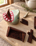 Shark and Broken Boat Cake Topper laid out on a wooden board
