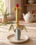 Large Gold Sword Cake Topper on a cream plate
