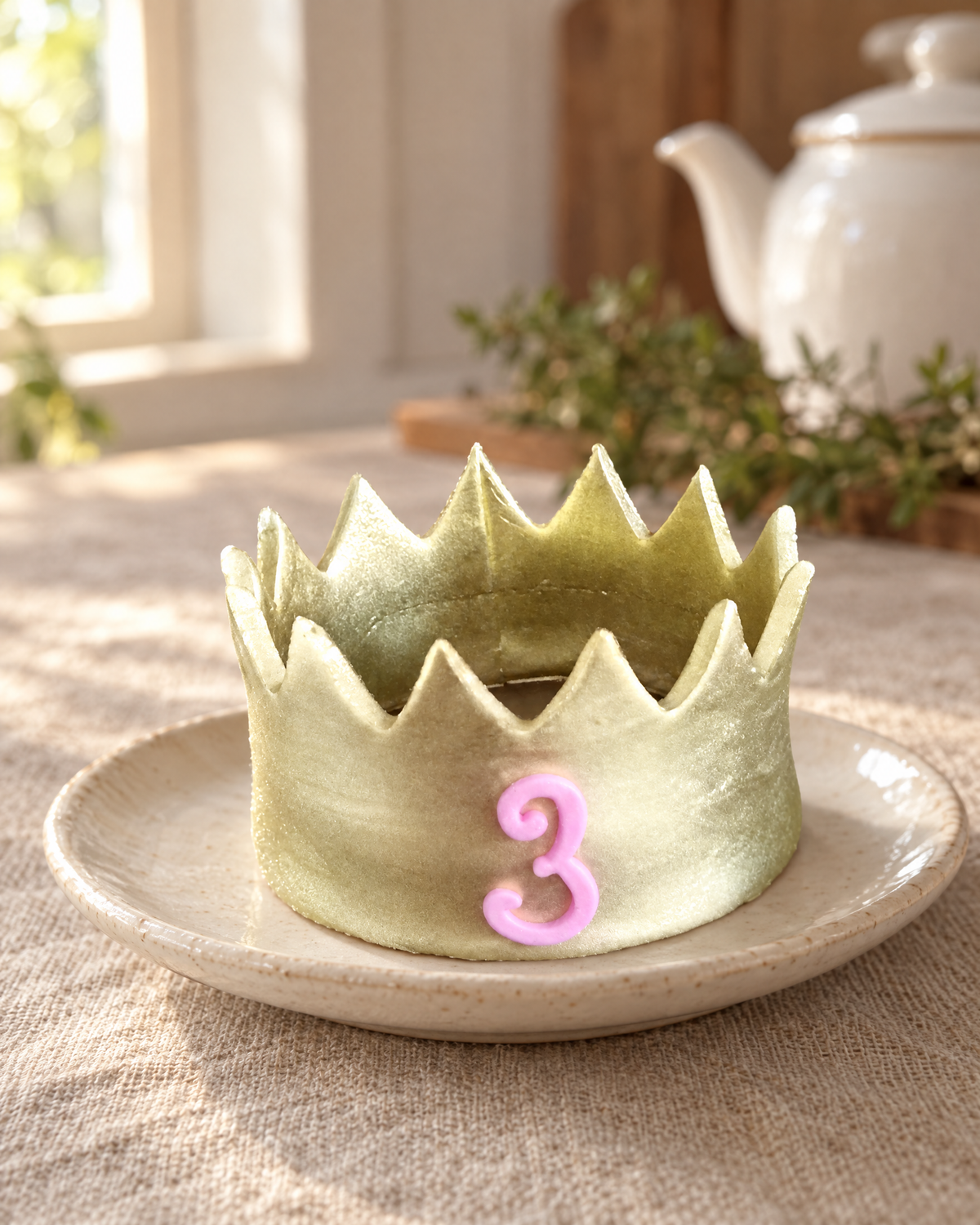 Gold Gum Paste Crown Cake Topper on a cream plate