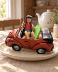 Girl in Convertible Car Cake Topper on a cream plate