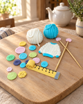 Knitted Jumper and Wool Cake Topper Set laid out on a wooden board